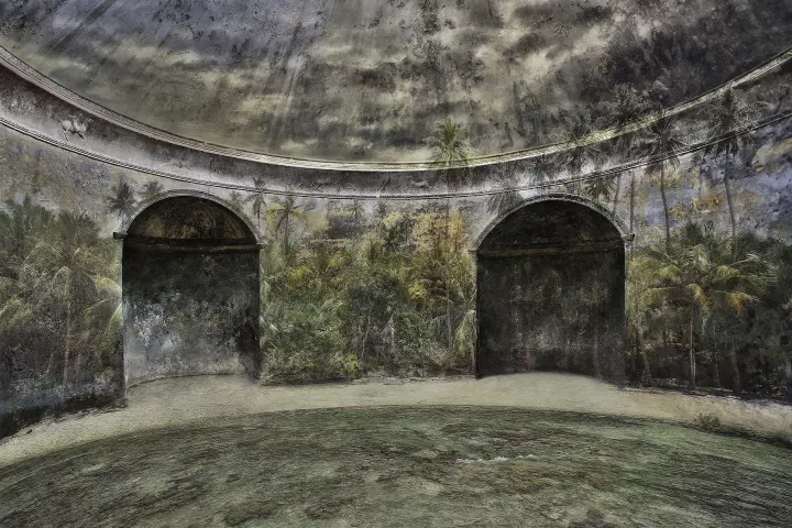 Alice 002 La mer de larmes Dans une pièces ronde avec deux portes, une plage avec une île en surimpression sur les murs.