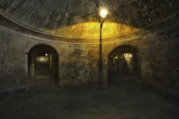 Alice 005 Le chat Dans une pièces ronde avec deux portes, un réverbère éclaire une rue dans la nuit.
