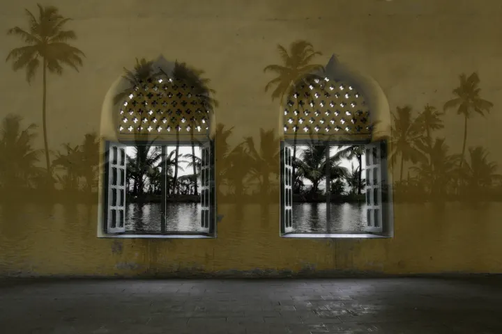 Deux fenêtres cintrées ouvertes sur des palmiers et une étendue d’eau, superposées à un mur ocre.